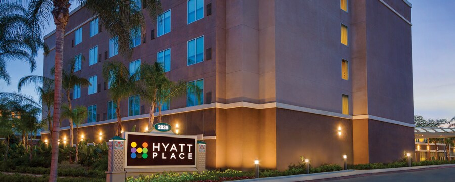 The exterior of Hyatt Place at Anaheim Resort/Convention Center at night surrounded by palm trees