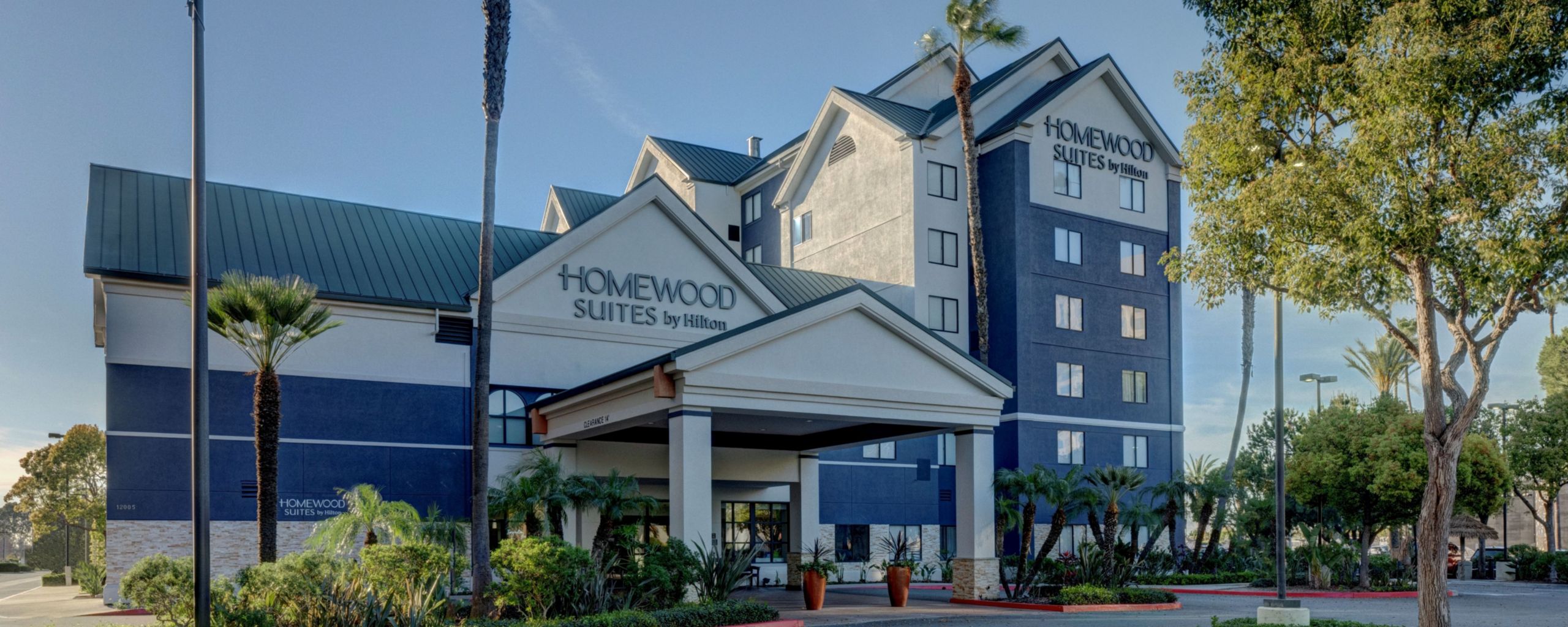 Exterior of Homewood Suites by Hilton Anaheim Maingate Area with a covered entrance and palm trees