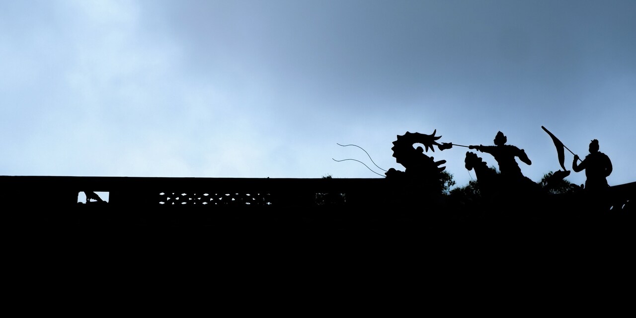 A wall featuring statues of a dragon and 2 warriors A wall featuring statues of a dragon and 2 warriors