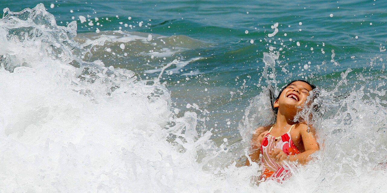 Waves splash a young girl playing in the surf Waves splash a young girl playing in the surf