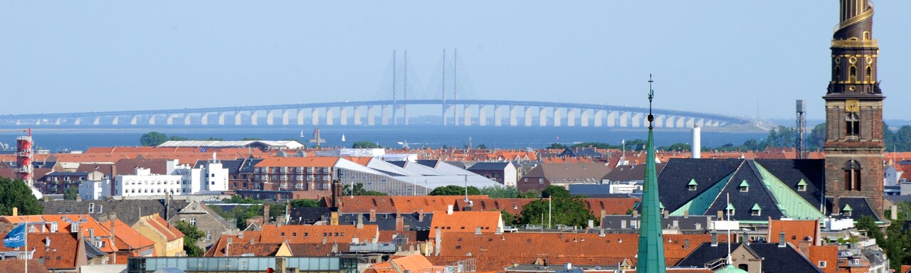 A boat docked at the Copenhagen harbor near European row houses A boat docked at the Copenhagen harbor near European row houses