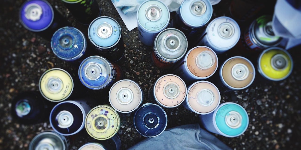 A birds-eye view of a variety of uncapped spray paint cans A birds-eye view of a variety of uncapped spray paint cans
