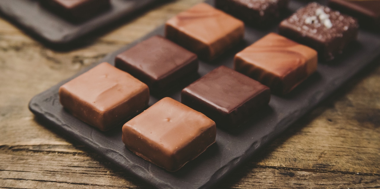 An assortment of 8 pieces of chocolate sits on a tray An assortment of 8 pieces of chocolate sits on a tray