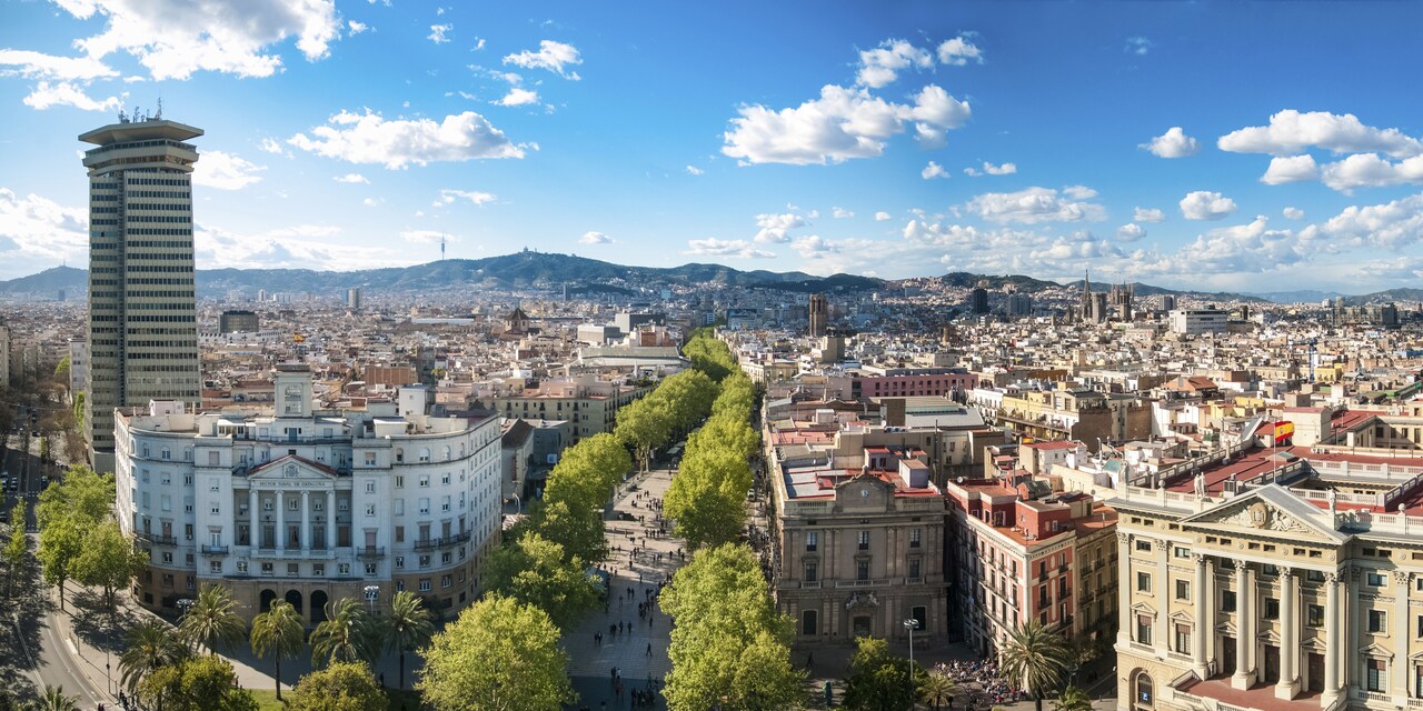 A city containing old and new buildings and cradled by mountains A city containing old and new buildings and cradled by mountains
