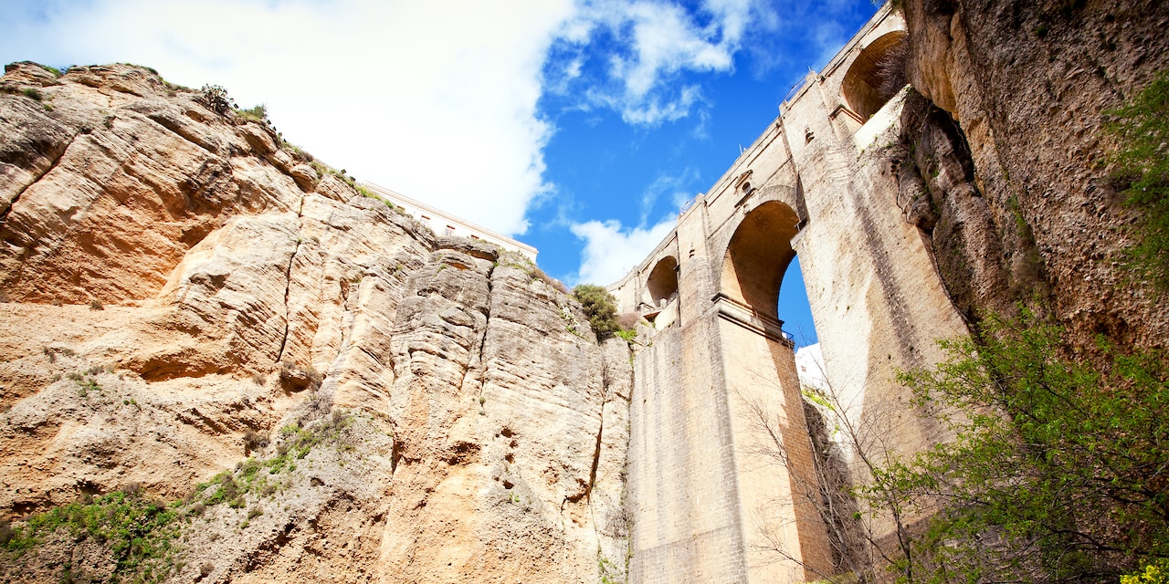 The Puente Nuevo bridge spans the gorge between 2 steep cliffs The Puente Nuevo bridge spans the gorge between 2 steep cliffs