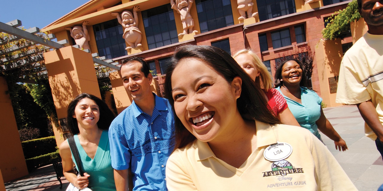 An Adventure Guide and Guests at The Walt Disney Studios and statues of the 7 Dwarves on a building An Adventure Guide and Guests at The Walt Disney Studios and statues of the 7 Dwarves on a building