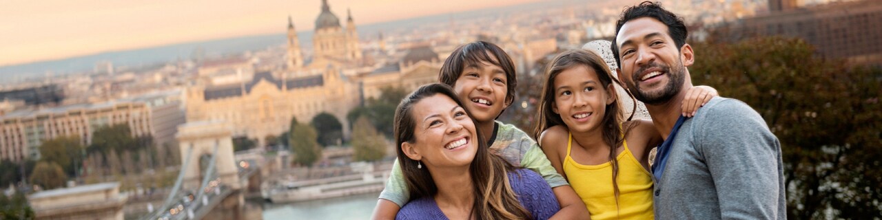 A family of Guests pose for a picture with a wide view of the city's historic buildings behind them