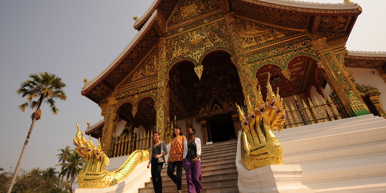 3 teenage girls walk down the steps of an ornate building