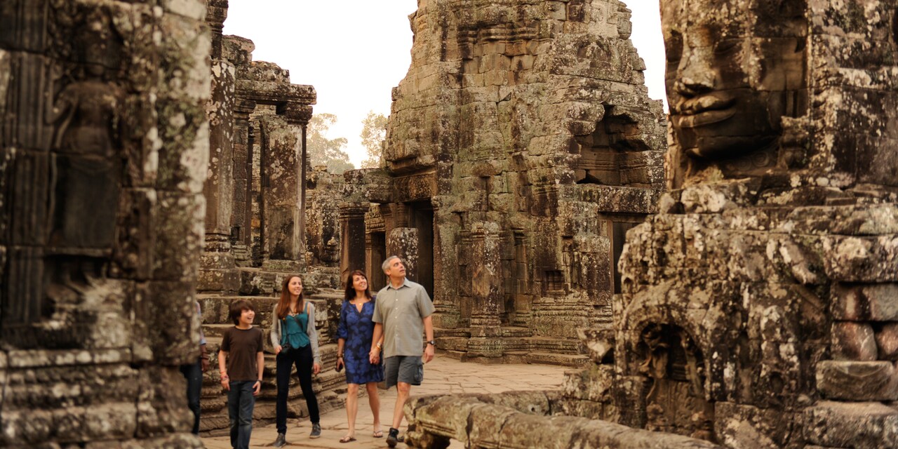 A family of 4 walks through towering ruins
