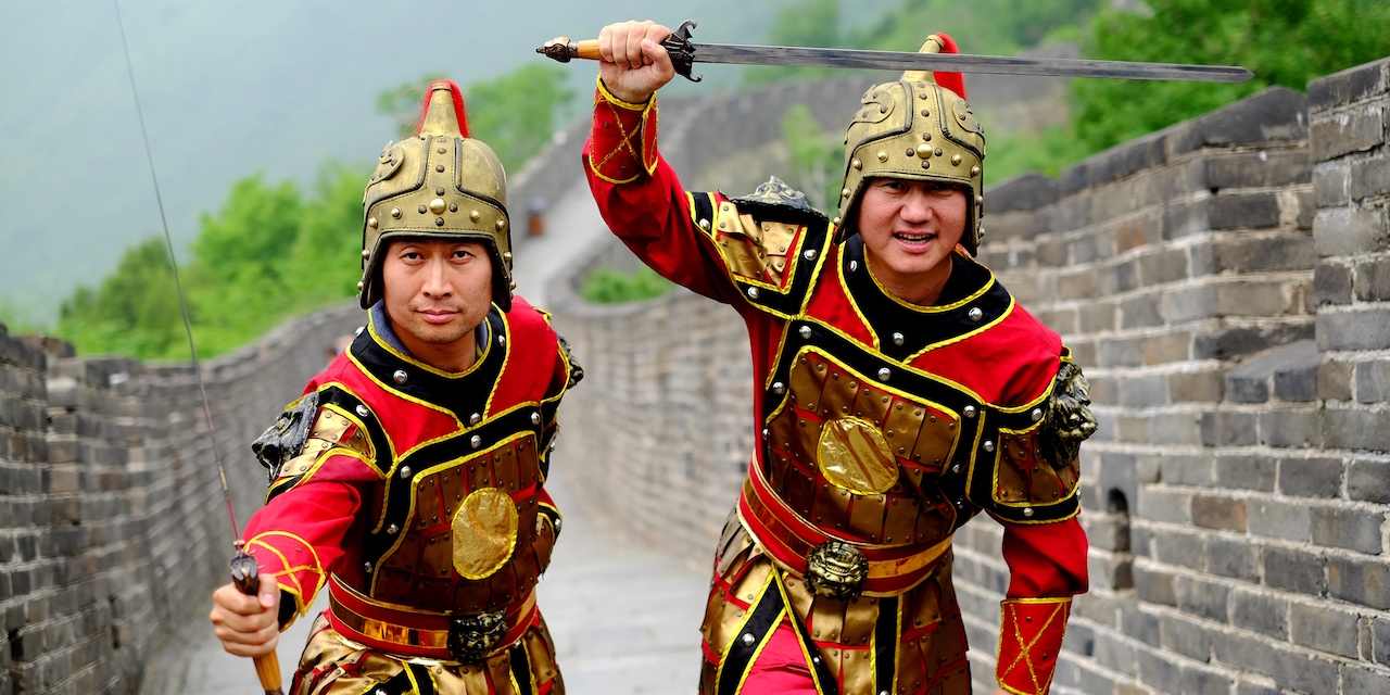 Two costumed Chinese guards with swords on the Great Wall of China