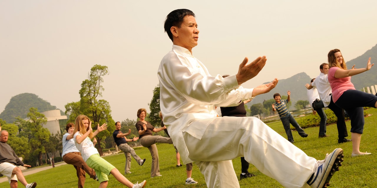 A dozen people practice Tai Chin on a lawn A dozen people practice Tai Chin on a lawn