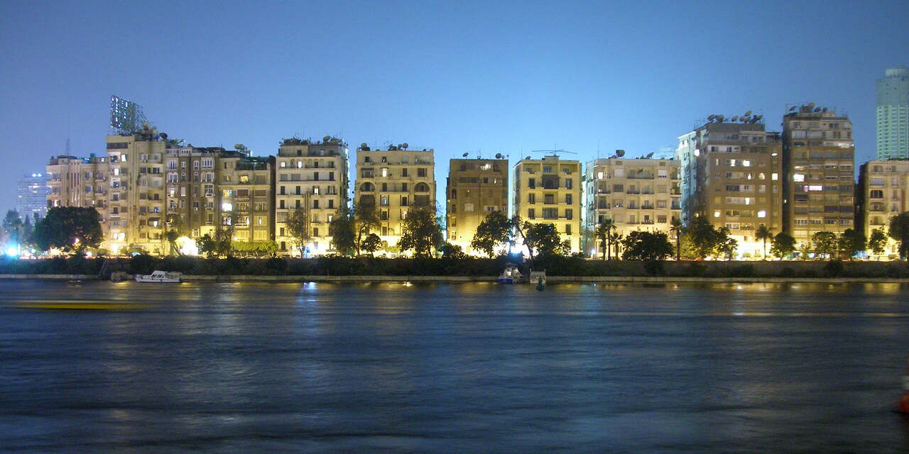 Lit up buildings of the Cairo, Egypt skyline along the Nile River at dusk Lit up buildings of the Cairo, Egypt skyline along the Nile River at dusk