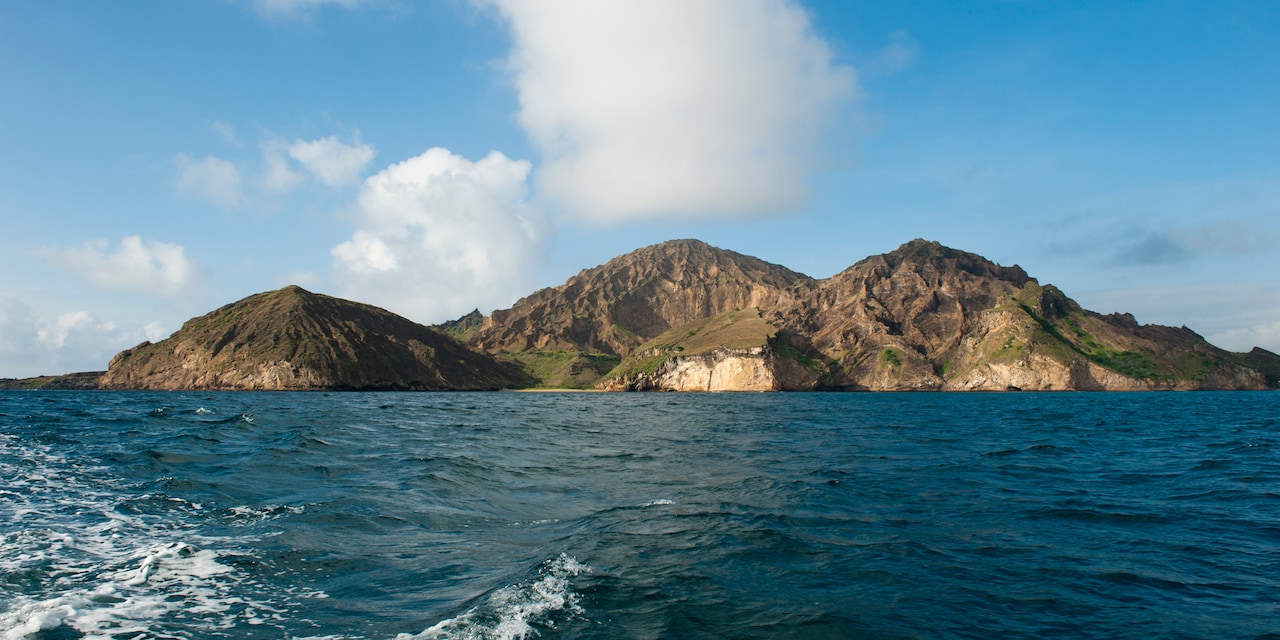 A view of an island mountain range seen from the ocean A view of an island mountain range seen from the ocean