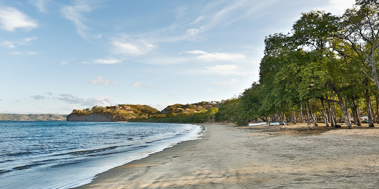 The calm waters and tree lined sands of Playa Panama in Guanacaste, Costa Rica