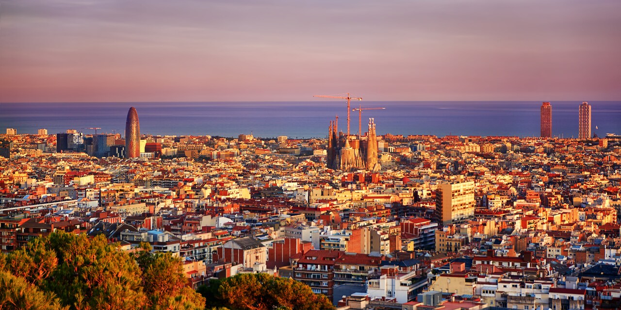 A view of the city of Barcelona with the Sagrada Famíla in the center and the Balearic Sea in the distance