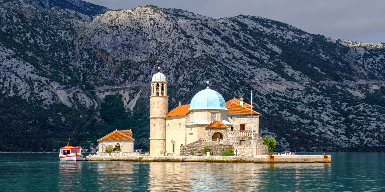 Our Lady of the Rocks Church on an island near a mountain in Kotor Bay in Montenegro
