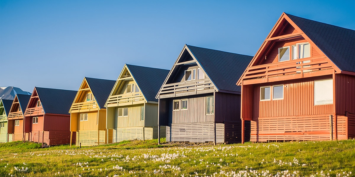 A row of wooden houses on a grassy plain in Longyearbyen