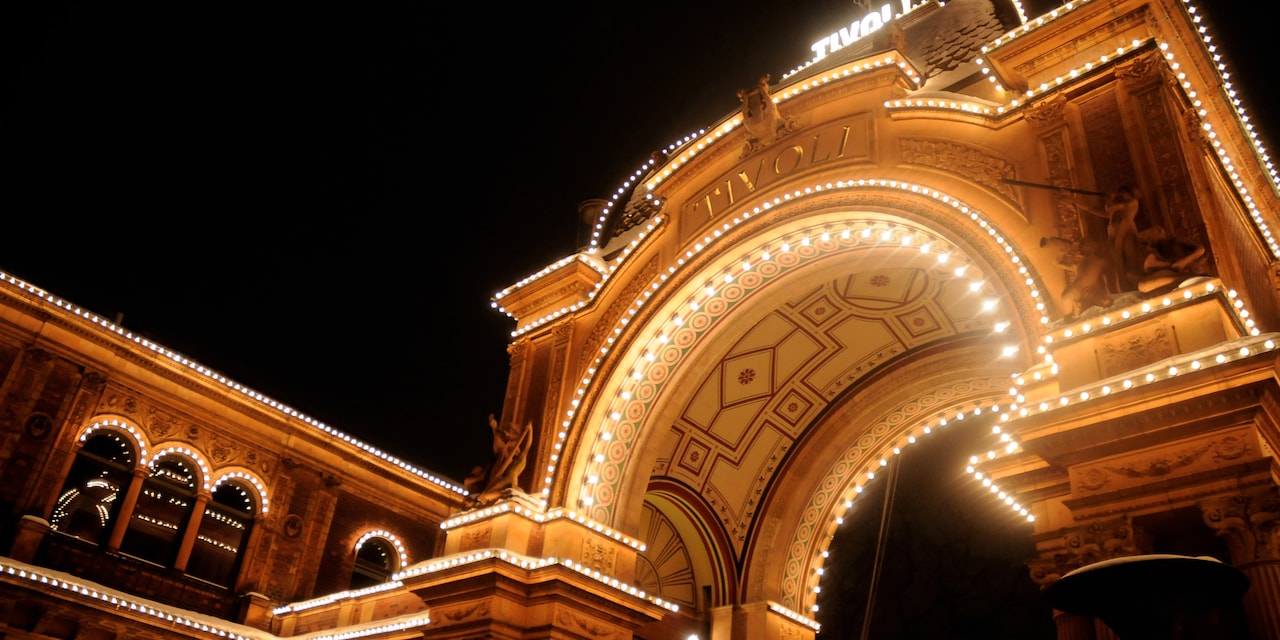 The arched entrance of Tivoli Gardens at night