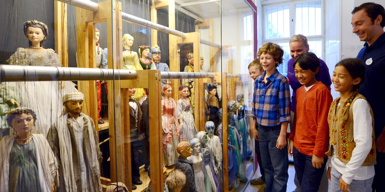 Children look at a collection of marionettes Children look at a collection of marionettes