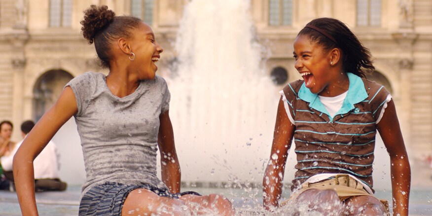 Two girls splash in a fountain