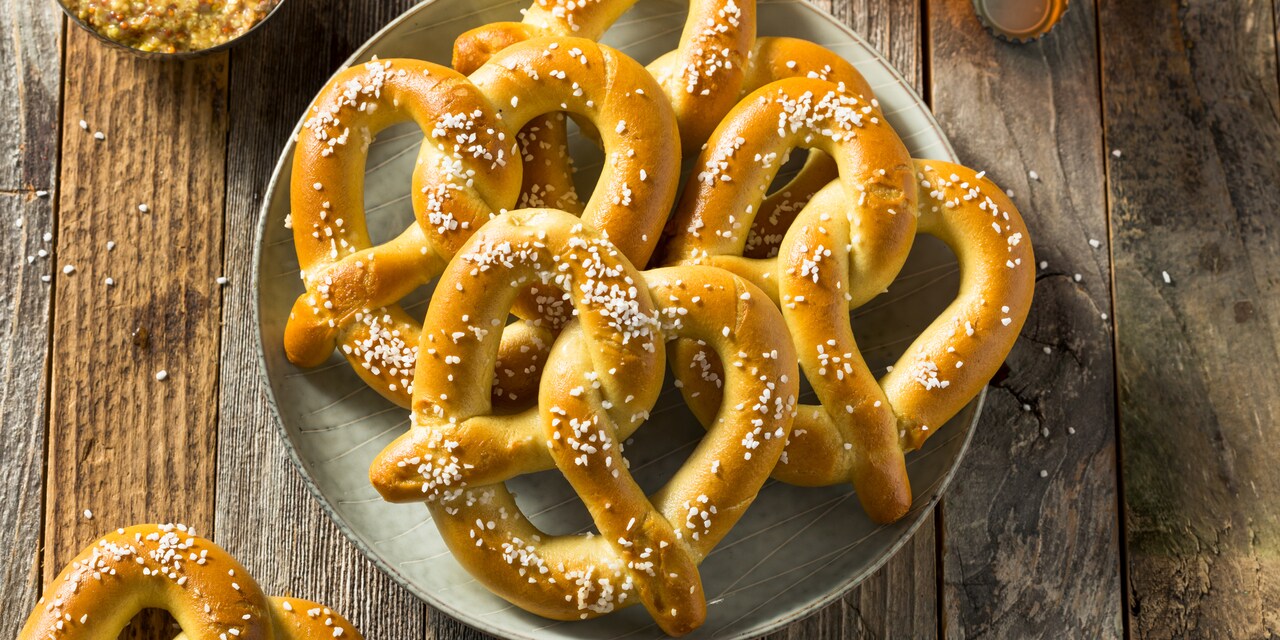 A plate with four pretzels on a wood table A plate with four pretzels on a wood table