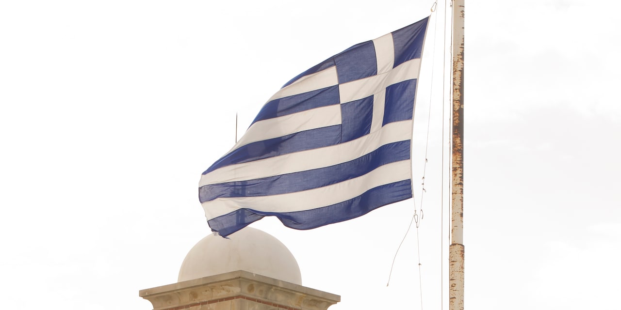 The Greek flag atop a flagpole billows in the wind The Greek flag atop a flagpole billows in the wind