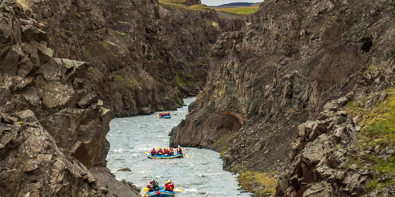 A group of 3 rafts are white water rafting between the rocky terrain of Skagafjörður A group of 3 rafts are white water rafting between the rocky terrain of Skagafjörður