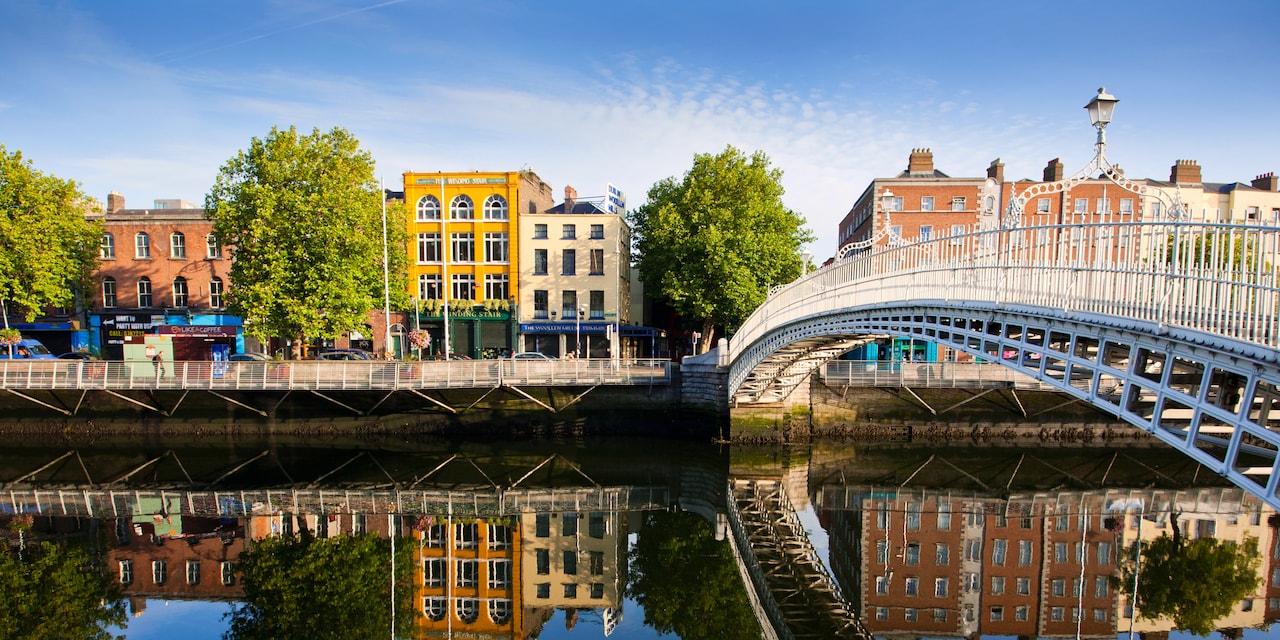 Dublin’s cast iron Ha’penny Bridge spans the River Liffey to a building-lined street, which is reflected in the river below
Dublin’s cast iron Ha’penny Bridge spans the River Liffey to a building-lined street, which is reflected in the river below