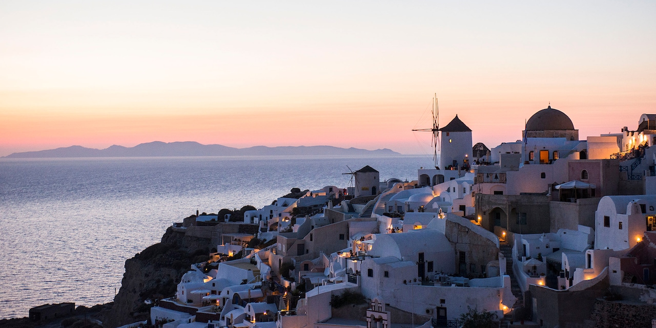 Buildings of the cliffside city of Santorini, Greece overlooking the Mediterranean Sea at nighttime Buildings of the cliffside city of Santorini, Greece overlooking the Mediterranean Sea at nighttime