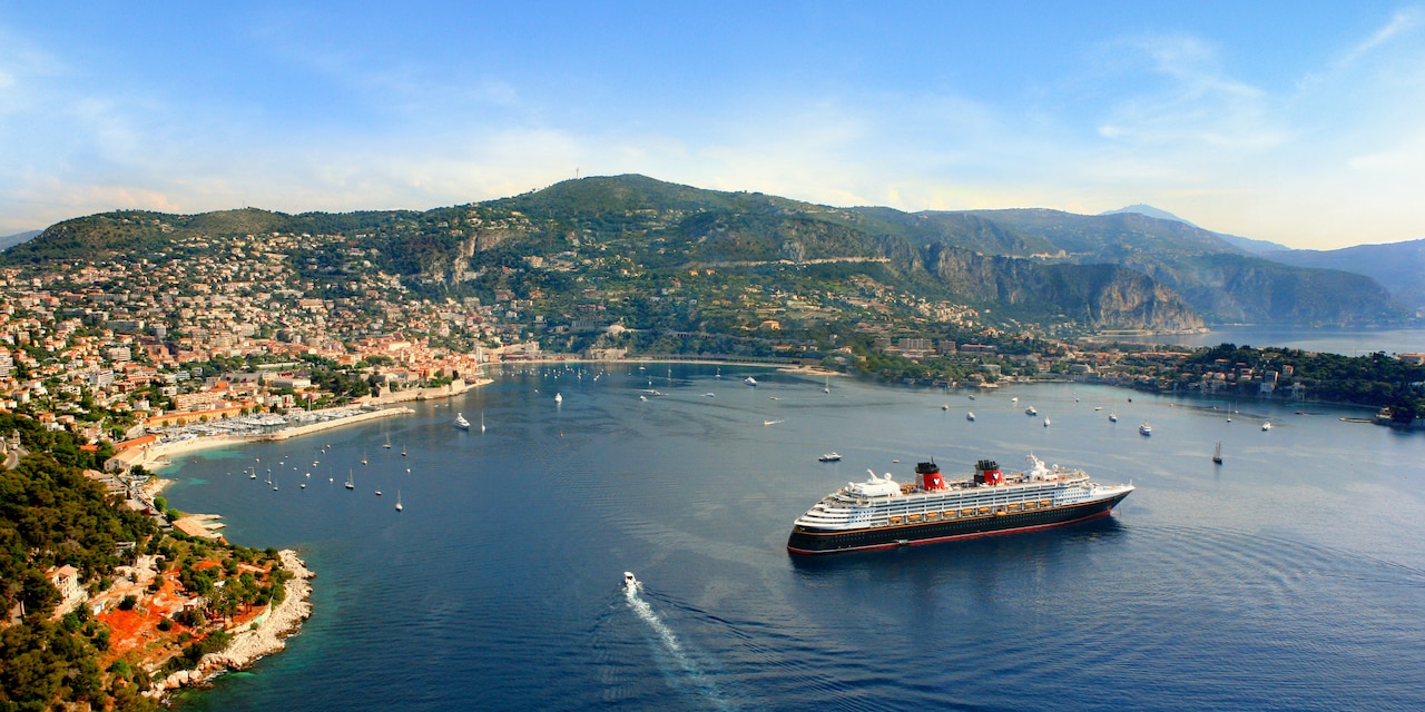 The Disney Magic cruise ship anchored off a coastal town on the Mediterranean Sea The Disney Magic cruise ship anchored off a coastal town on the Mediterranean Sea