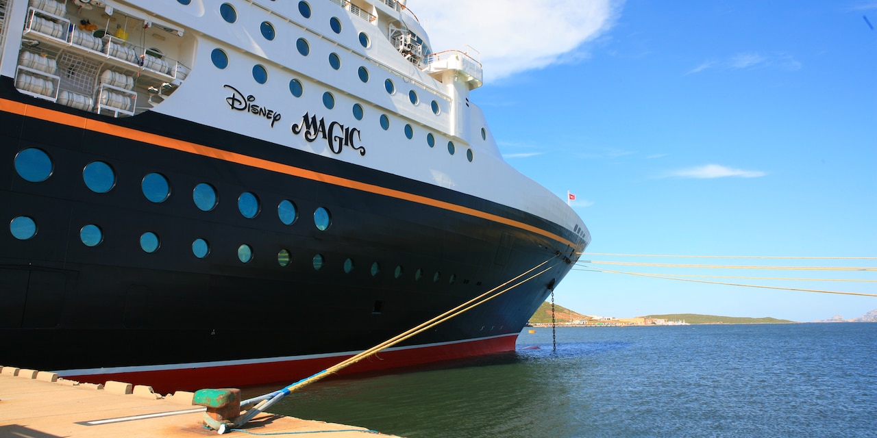 The side of the Disney Magic cruise ship which is tethered to a dock The side of the Disney Magic cruise ship which is tethered to a dock