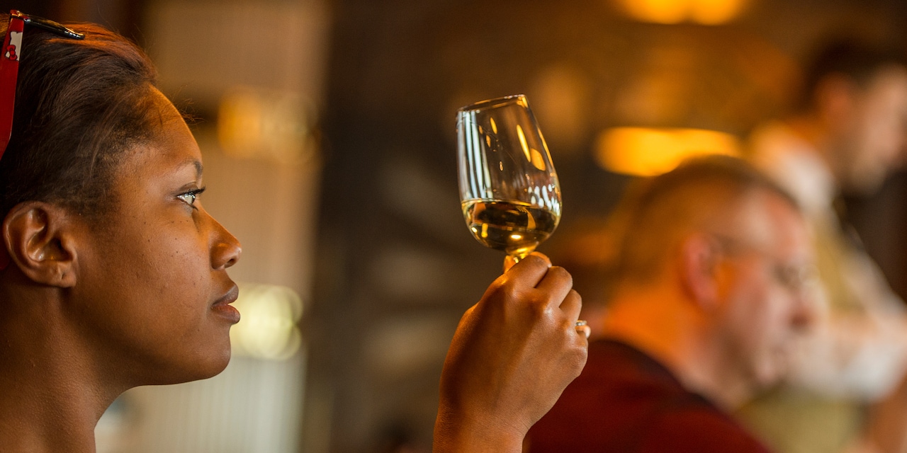 A woman inspects a glass of wine A woman inspects a glass of wine