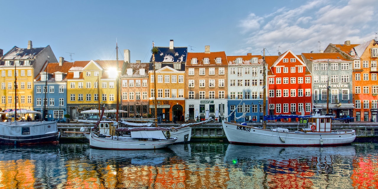 Boats docked in the waters along a row of buildings on Copenhagen’s waterfront Boats docked in the waters along a row of buildings on Copenhagen’s waterfront