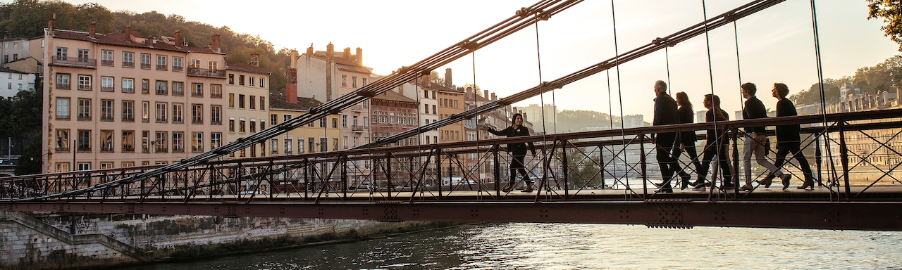 An Adventure Guide leads a group of Adventurers across a bridge spanning the Rhône River An Adventure Guide leads a group of Adventurers across a bridge spanning the Rhône River