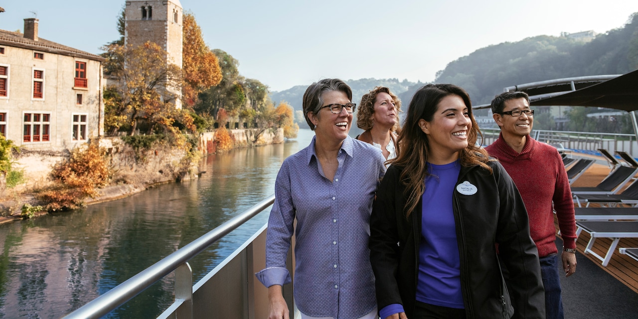 An Adventure Guide and 3 Adventurers pass a stone building and tower as they sail down the Rhône Rive An Adventure Guide and 3 Adventurers pass a stone building and tower as they sail down the Rhône Rive