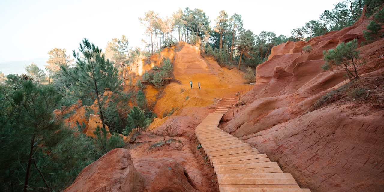 Wooden steps lead down the Ochre Trail where a couple stand in the distance Wooden steps lead down the Ochre Trail where a couple stand in the distance