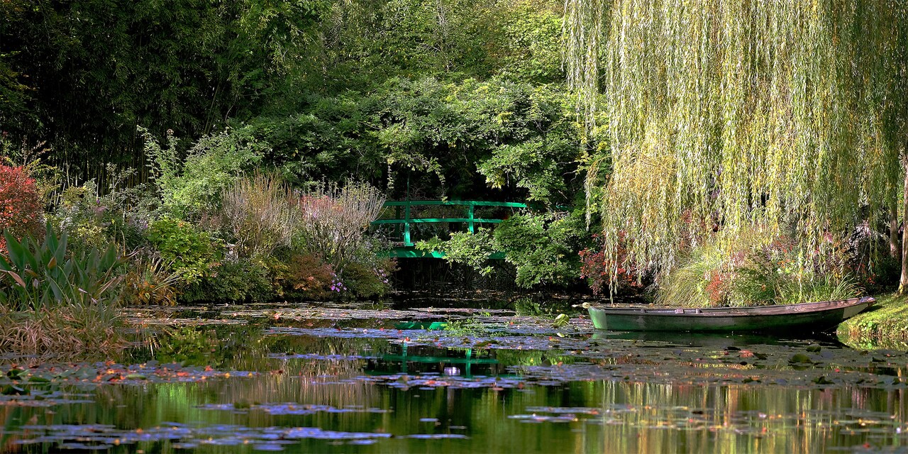 A rowboat sits in the pond amongst the gardens at the house of Claude Monet in Giverny, France
