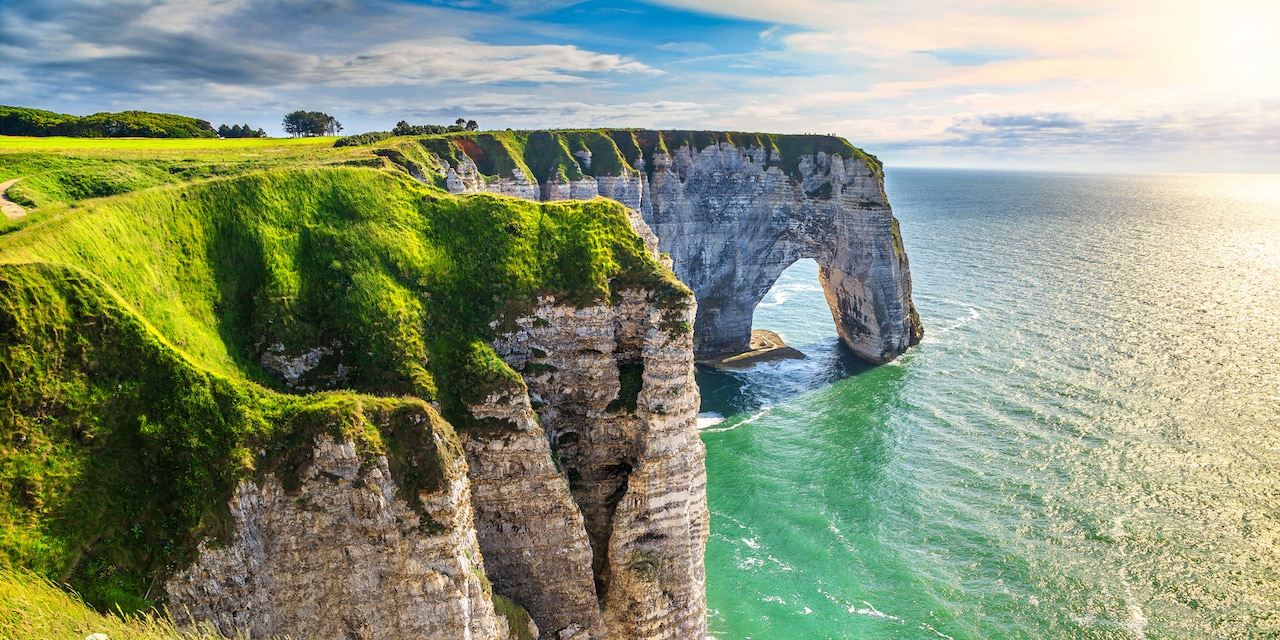 Stand in awe at the white Cliffs of Étretat and its striking rock formations that rise from the sea.