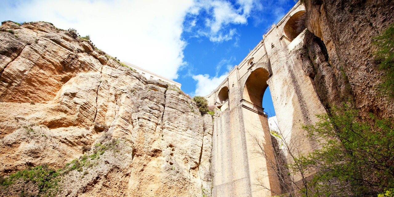 The Puente Nuevo bridge spans the gorge between 2 steep cliffs The Puente Nuevo bridge spans the gorge between 2 steep cliffs