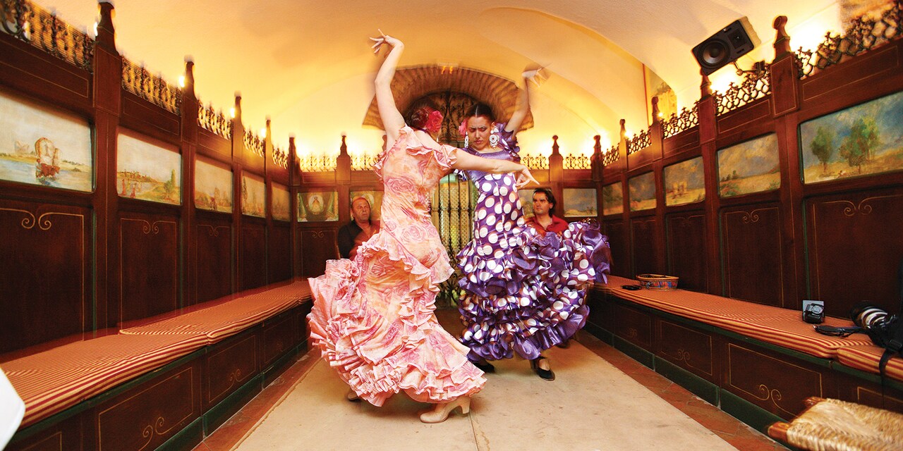 Two female flamenco dancers perform in traditional dress