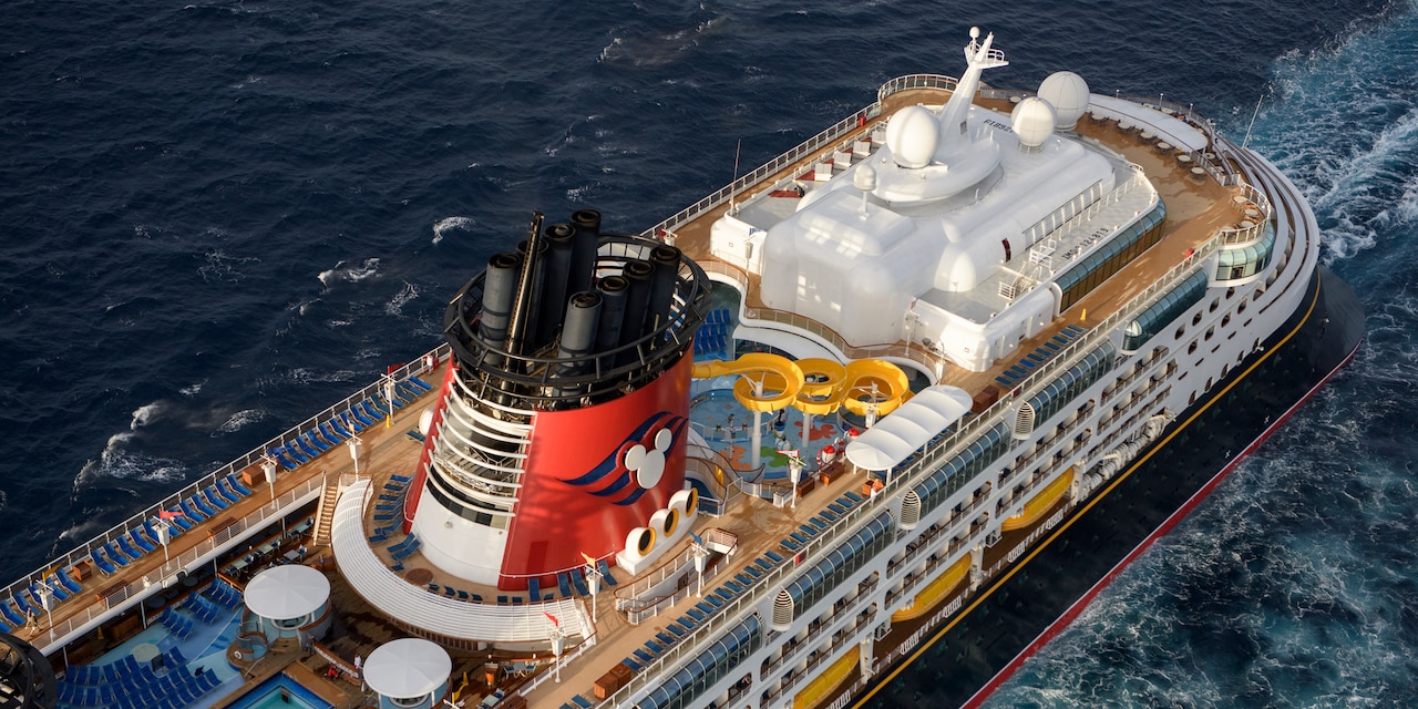 A birds-eye view of the top deck of the Disney Wonder cruise ship as it sails across the sea A birds-eye view of the top deck of the Disney Wonder cruise ship as it sails across the sea