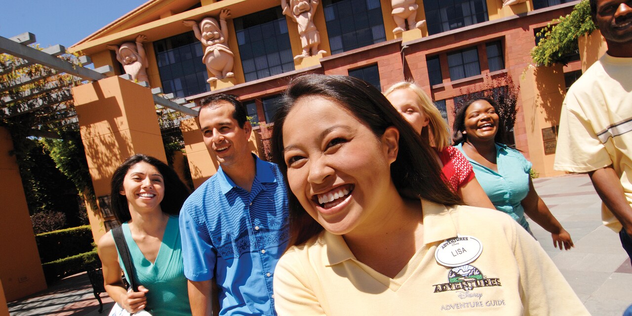 An Adventure Guide and Guests at The Walt Disney Studios and statues of the 7 Dwarves on a building An Adventure Guide and Guests at The Walt Disney Studios and statues of the 7 Dwarves on a building