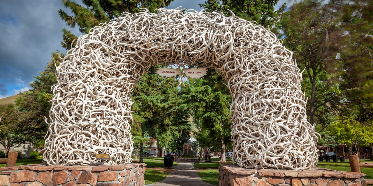 An arch made from elk antlers with a sign that reads ‘Jackson Hole, WY’