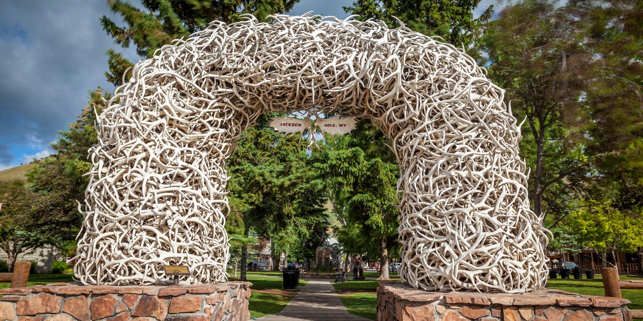 An arch made from elk antlers with a sign that reads ‘Jackson Hole, WY’ An arch made from elk antlers with a sign that reads ‘Jackson Hole, WY’
