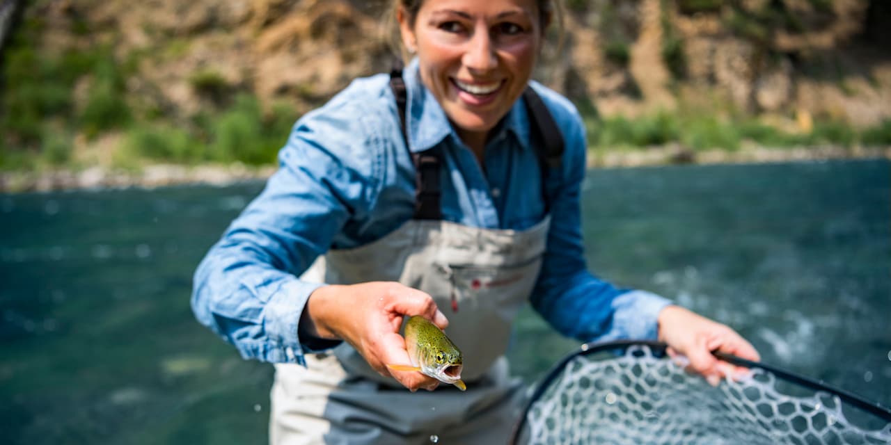 A woman holding a net and a fish A woman holding a net and a fish