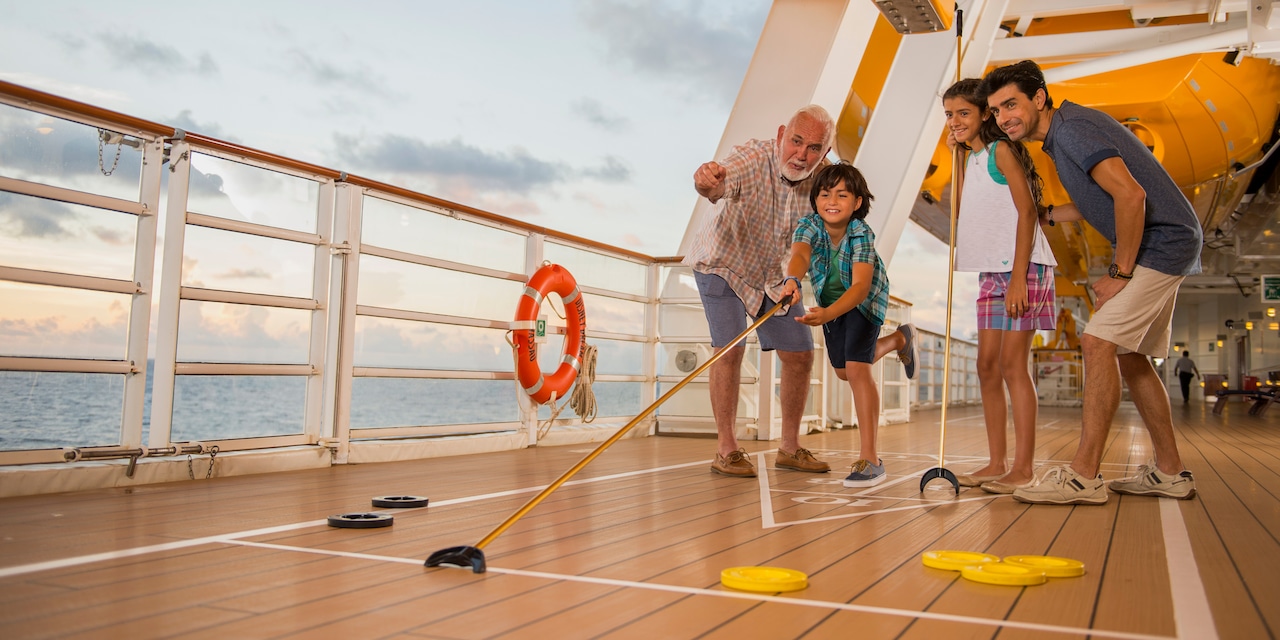A family plays shuffle board on the deck of a ship A family plays shuffle board on the deck of a ship