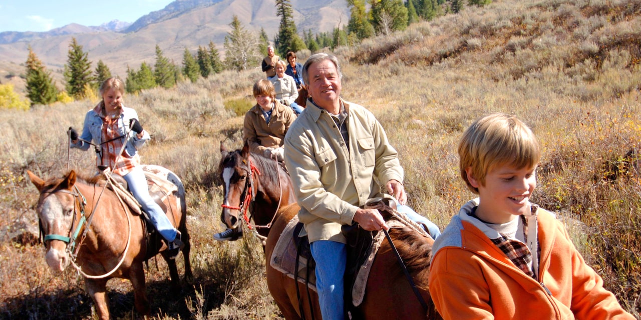 A family horseback riding in a field A family horseback riding in a field