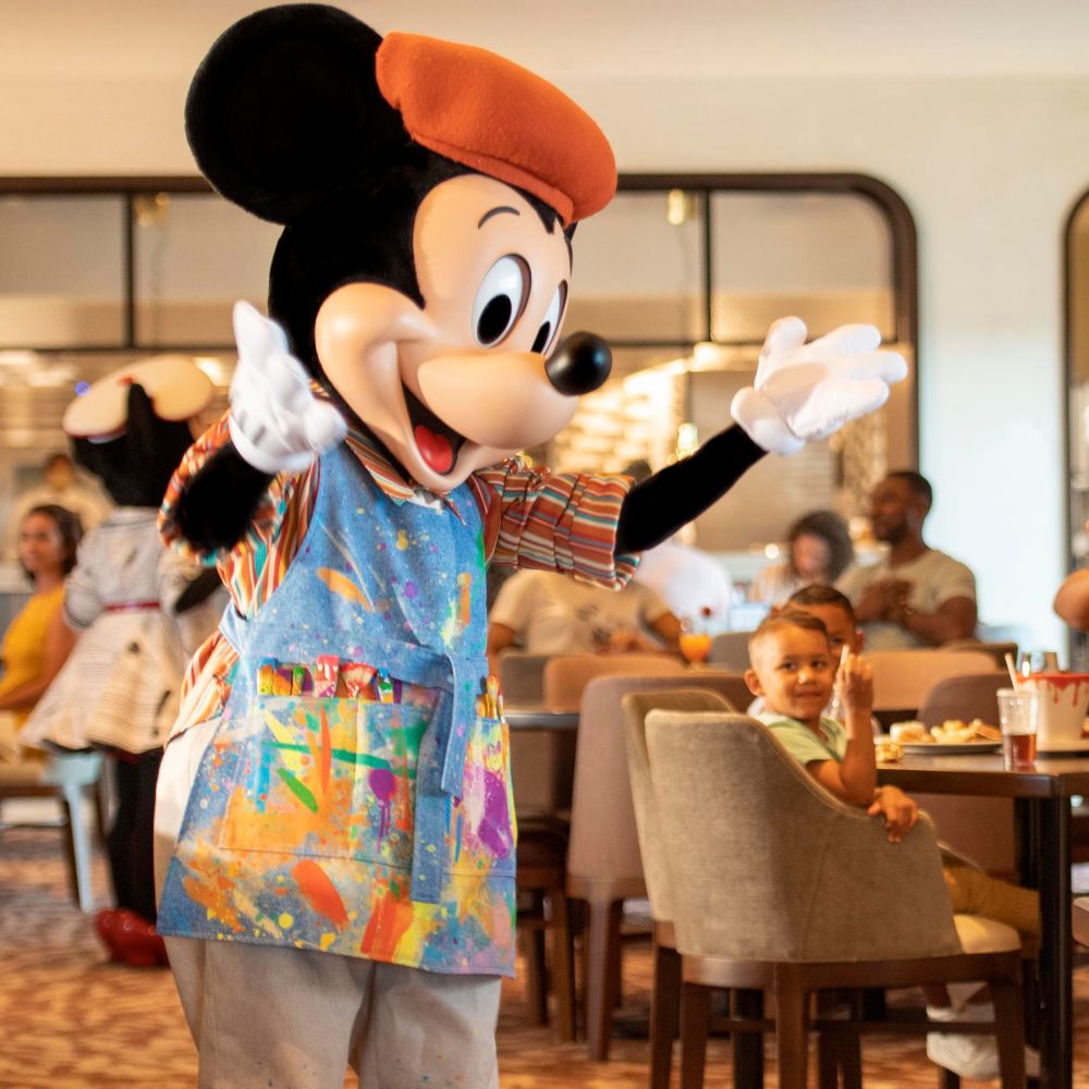 Mickey Mouse interacts with a group of kids dining at Topolino's Terrace, Flavors of the Riviera