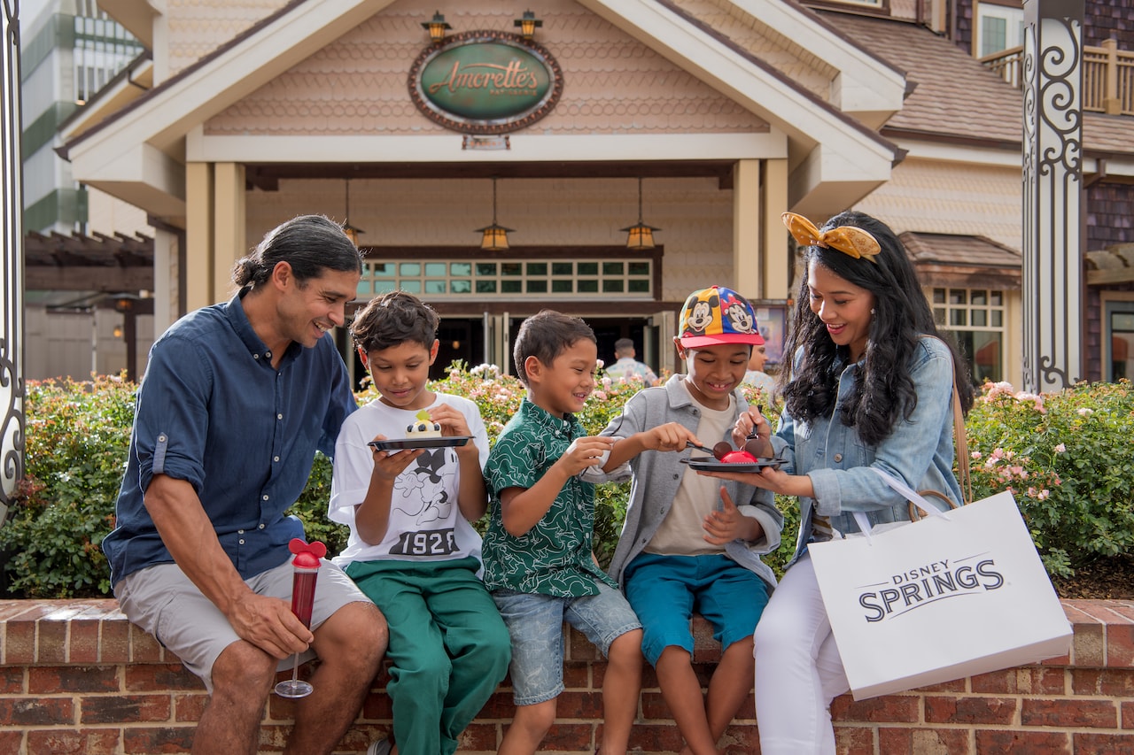 A family eating treats sitting in front of Amorette’s Patisserie in Disney Springs