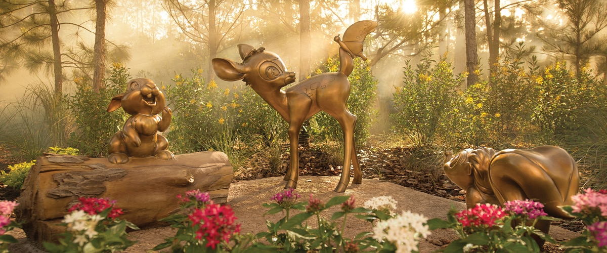A wooded outdoor area with statues of Bambi, Thumper and Flower from the film 'Bambi'